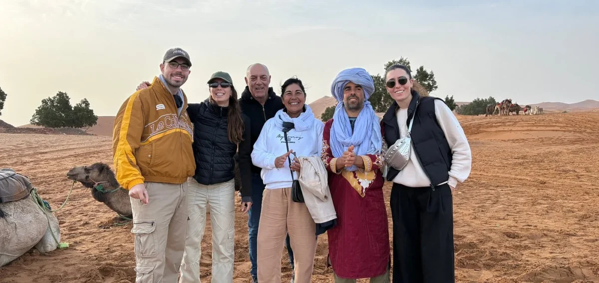 Travelers with local guide in Merzouga desert before the camel trek during a 3 days tour from Marrakech to Merzouga
