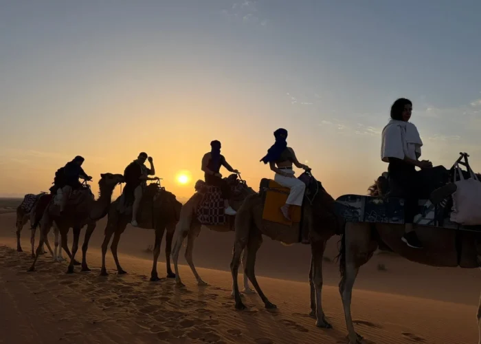 Paseo en camello al atardecer en las dunas de Erg Chebbi durante un tour por el desierto de 2 días desde Marrakech a Fez vía Merzouga.