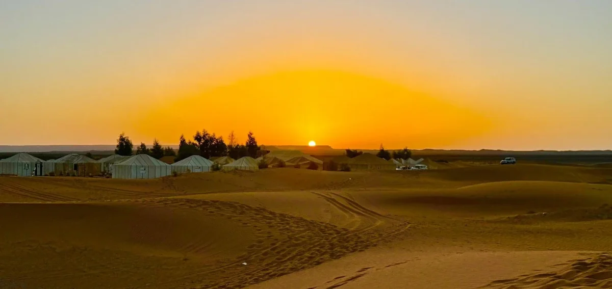 Sunset over Merzouga desert camp during a 4 days desert tour from Marrakech to Merzouga