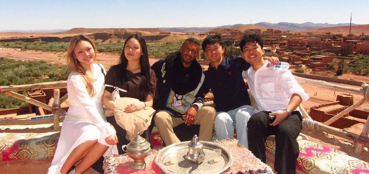 Travelers enjoying Moroccan tea near Ait Ben Haddou during a desert tour from Marrakech