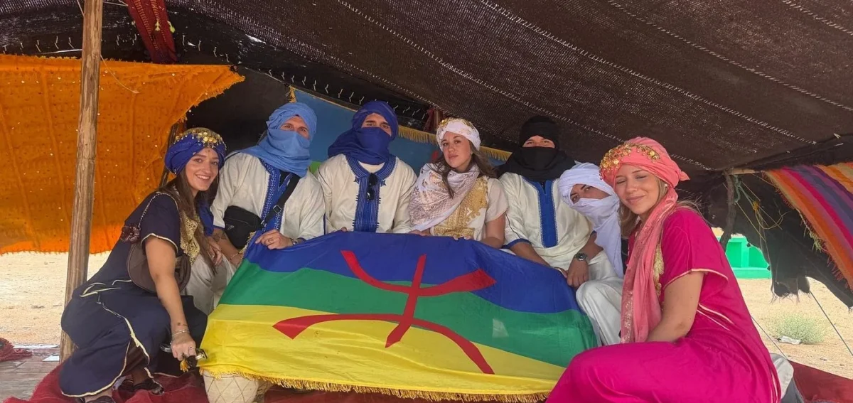 Travelers enjoying an Amazigh cultural experience with local people near Merzouga