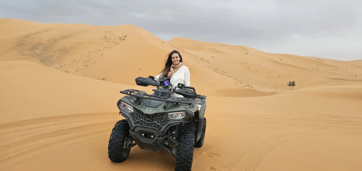 Traveler riding a quad bike across the Erg Chebbi dunes in Merzouga