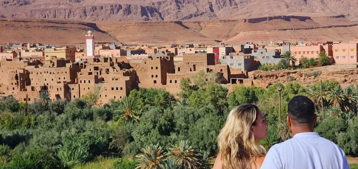 couple-view-oasis-valley-4-days-tour-fes-merzouga Couple enjoying the view of a Moroccan village and oasis valley on the 4 days tour from Fes to Merzouga