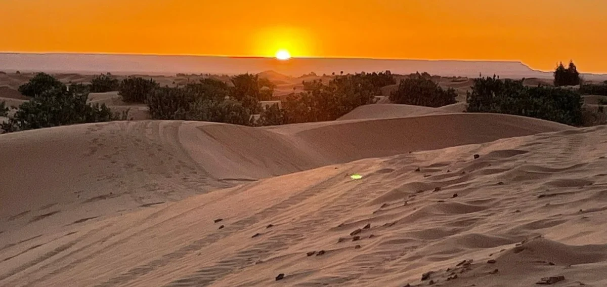 Sunset over the Merzouga desert dunes during a 3-day tour from Fes to Marrakech