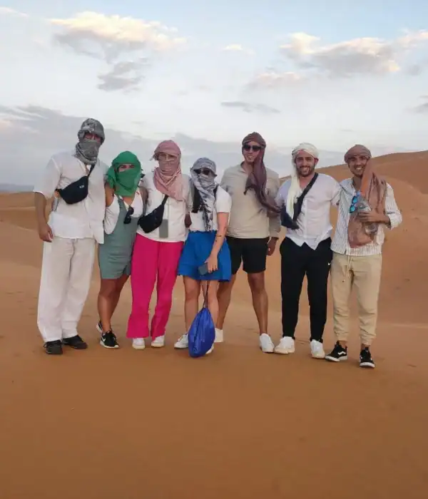 Foto de grupo en las dunas del Erg Chebbi cerca de Merzouga durante un tour de 5 días de Fez a Marrakech