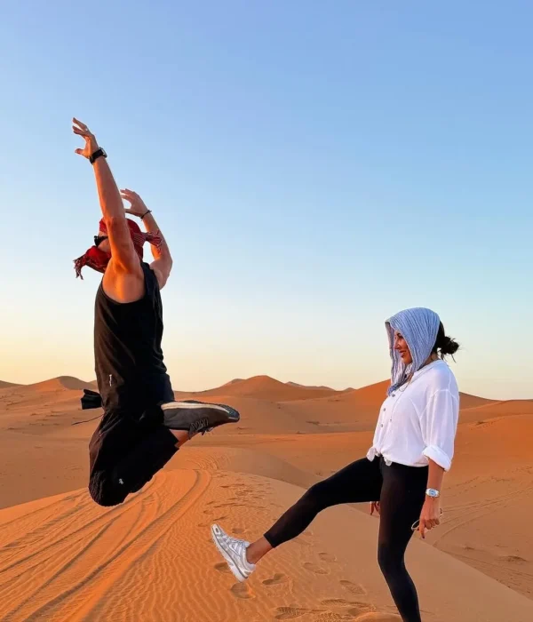 Viajeros en las dunas de arena de Erg Chebbi en Merzouga al atardecer en un tour de 7 días por el desierto desde Agadir