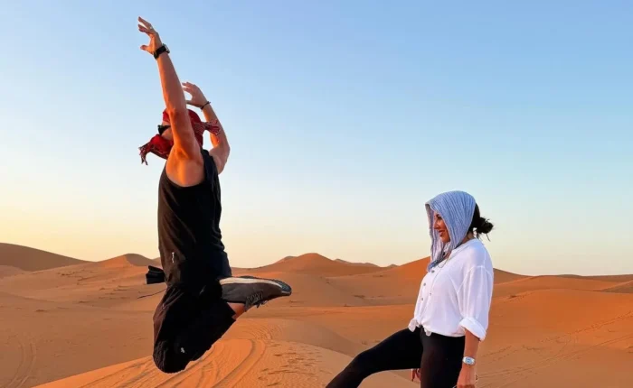 Travelers on the Erg Chebbi sand dunes in Merzouga at sunset on a 7-day Agadir desert tour