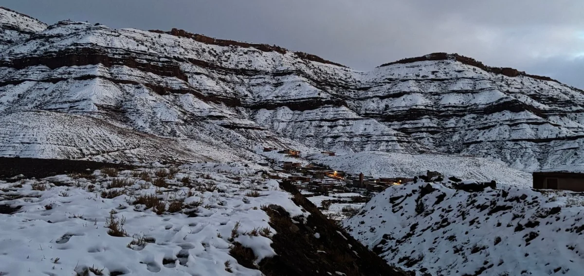 Snow-covered mountains and village in the Dades Valley during a winter desert tour from Agadir