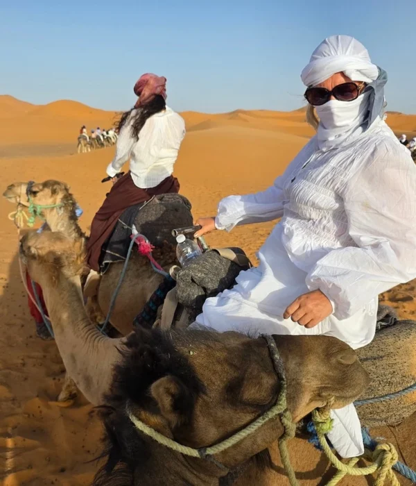Viajero montando en camello por las dunas de Erg Chebbi durante el tour de 4 días por el desierto de Agadir a Merzouga con final en Marrakech