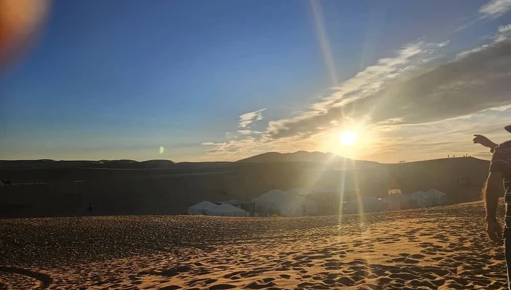 Sunset over the Erg Chebbi dunes beside a desert camp in Merzouga, Morocco.