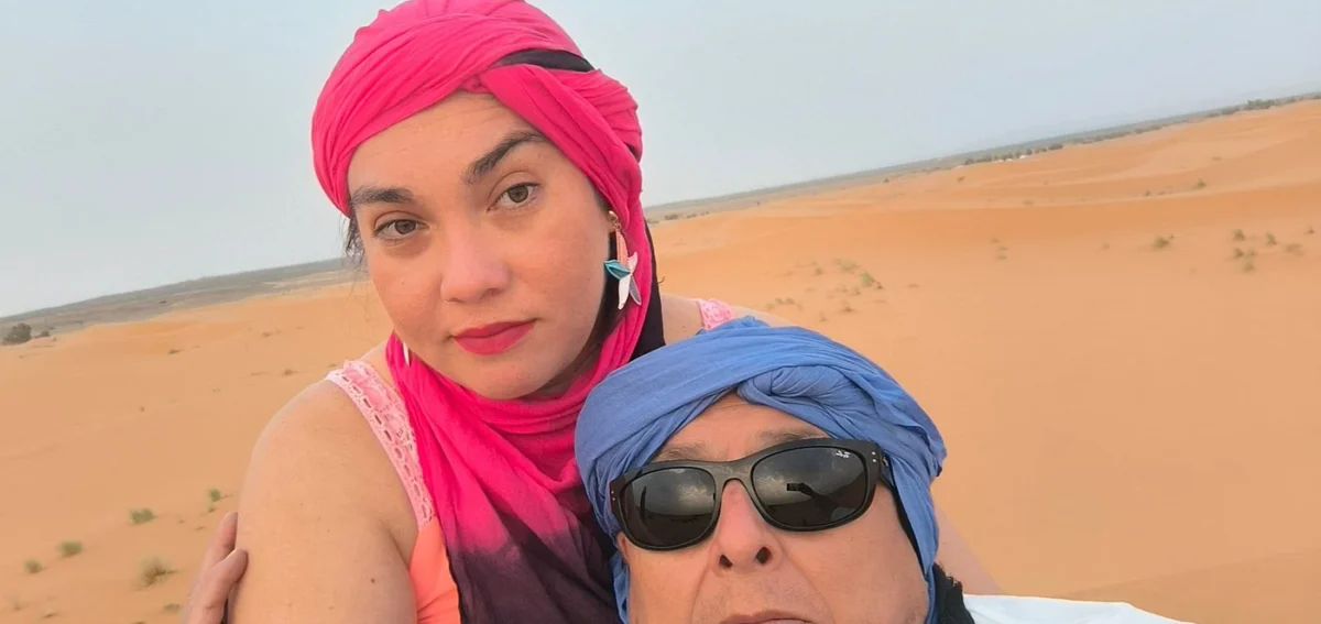 Travelers wearing desert scarves in the Erg Chebbi dunes near Merzouga