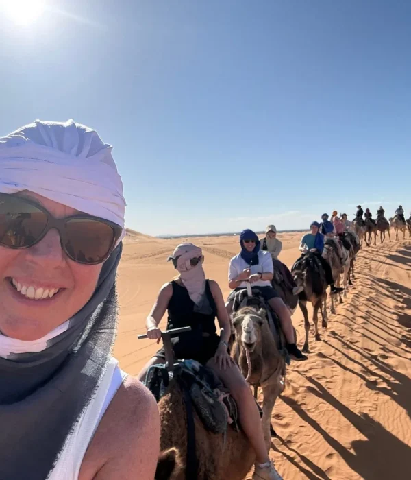 Travelers riding camels in the Merzouga Sahara Desert during a 3 days tour from Ouarzazate to Marrakech