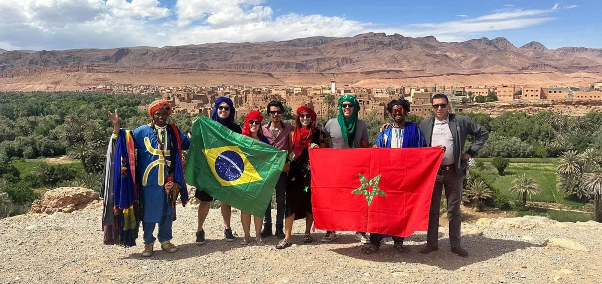 Travelers visiting southern Morocco during a private desert tour from Ouarzazate to Merzouga with local Berber guides and panoramic Atlas Mountain views