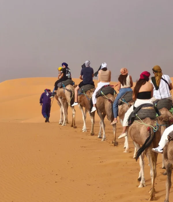 Viajeros montando en camello por las dunas de Erg Chebbi durante un tour al desierto de Merzouga